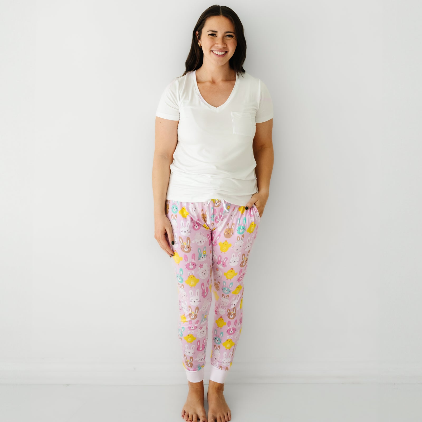 Woman wearing Pink Pastel Parade women's pajama pants paired with a coordinating Bright White women's pocket tee