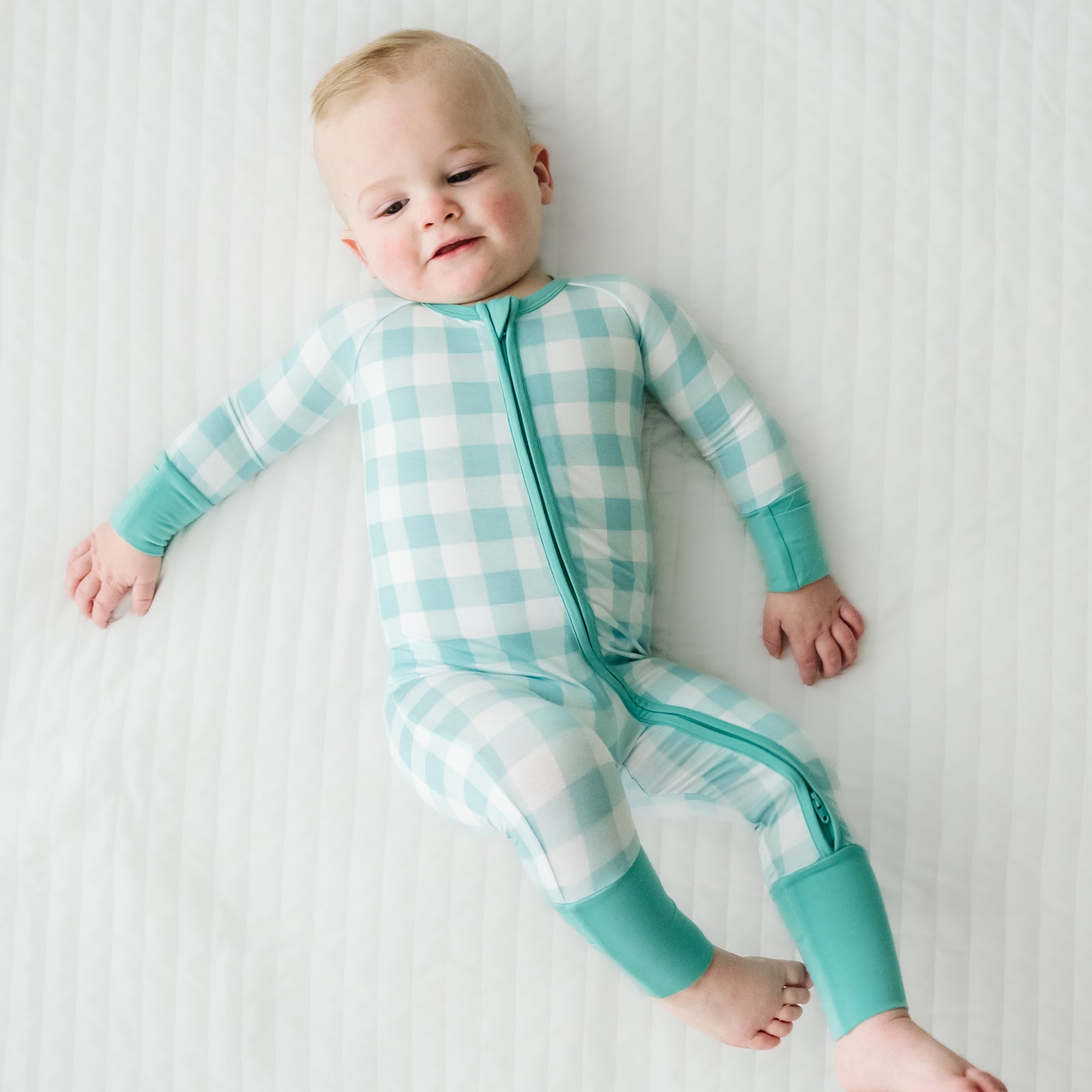 Alternate image of a child laying on a bed wearing a Aqua Gingham zippy