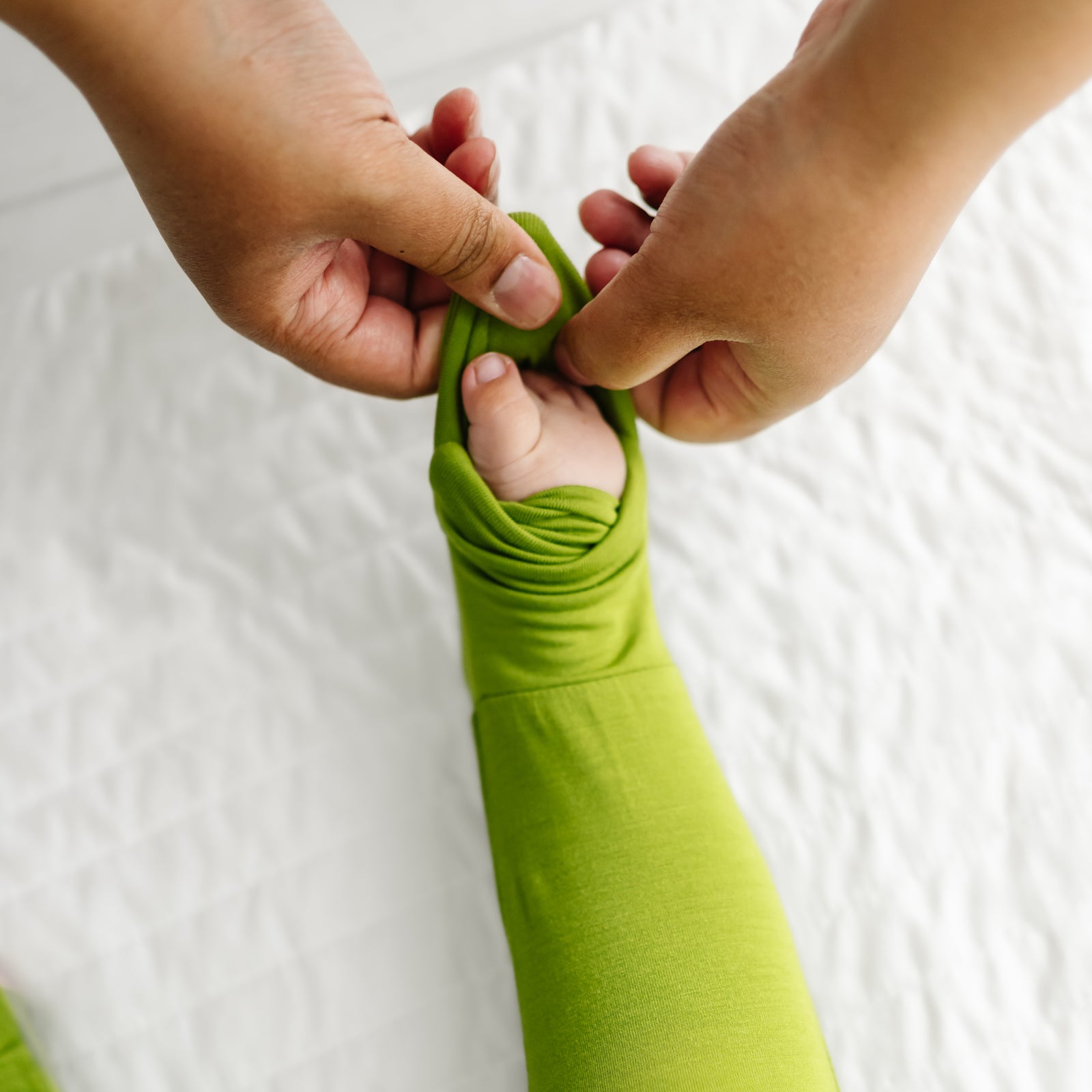 Mother folding over a foot cuff on their child wearing an Avocado zippy