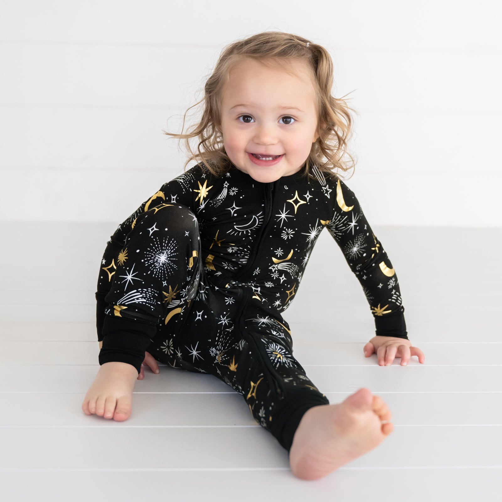 image of a child sitting wearing a Celebration Stars zippy