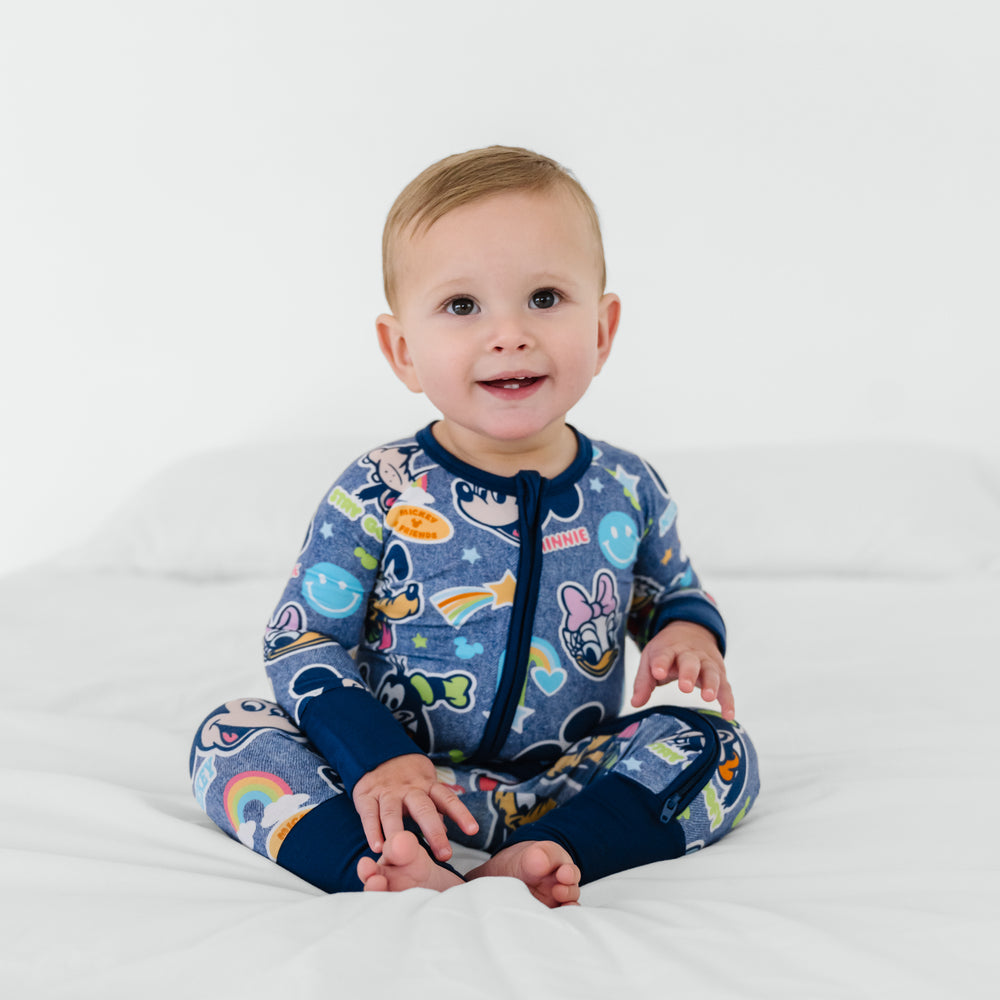 Baby sitting on a bed wearing Disney Mickey's Clubhouse bamboo pajamas