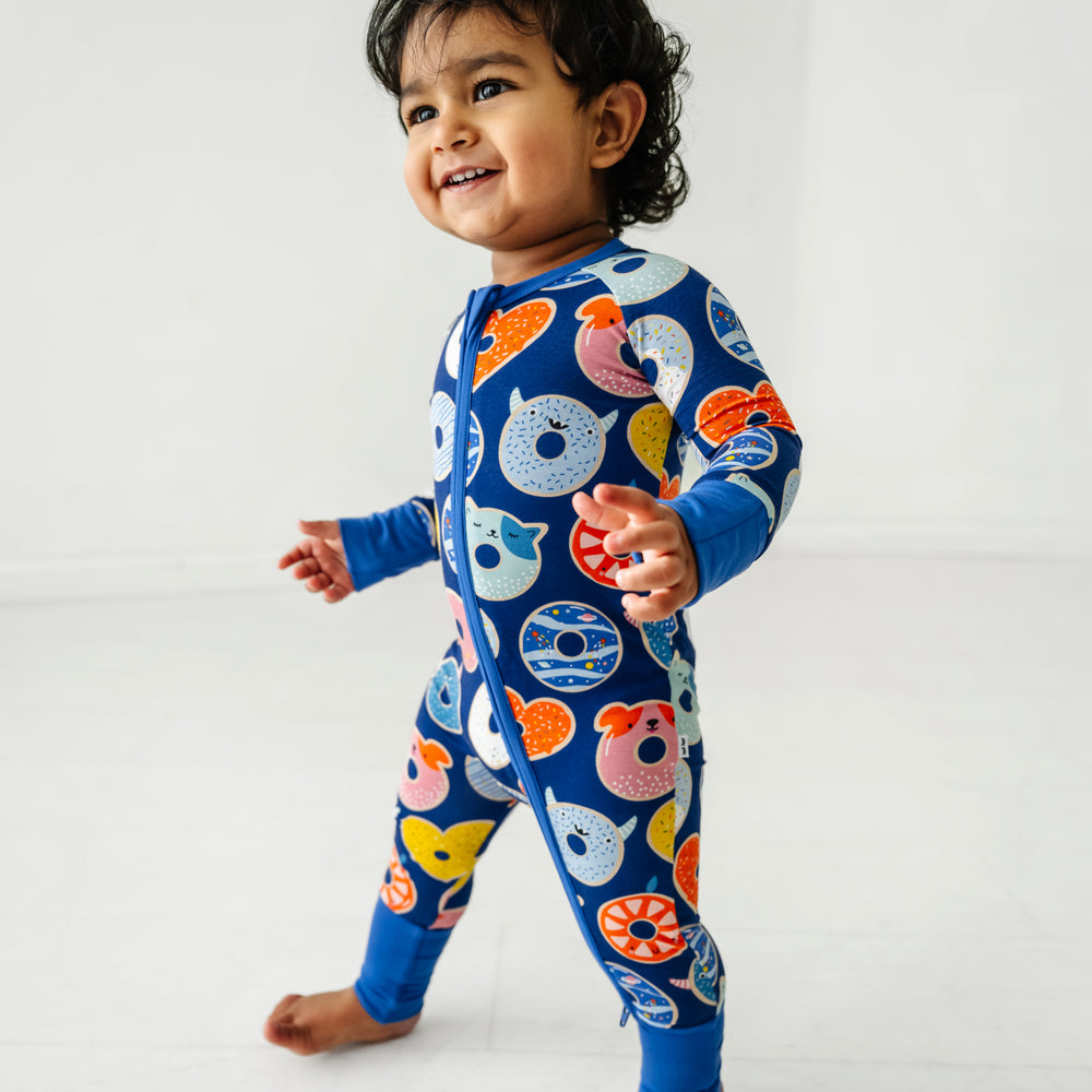 Child posing wearing a blue Donut Dreams zippy