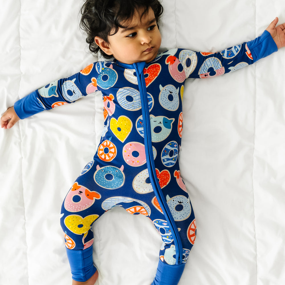 Click to see full screen - Child laying down wearing a blue Donut Dreams zippy