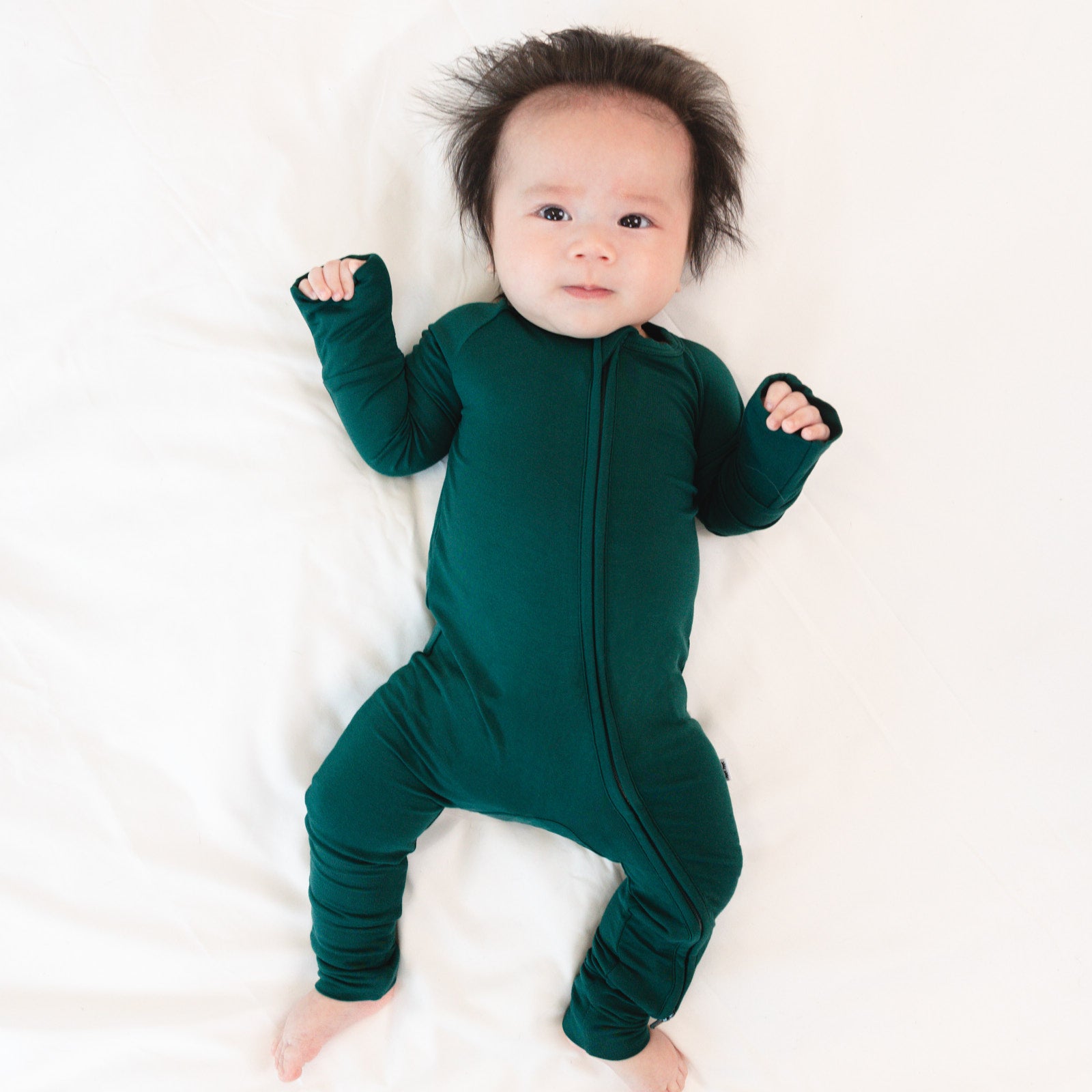 Top view image of baby laying down while wearing the Emerald Zippy