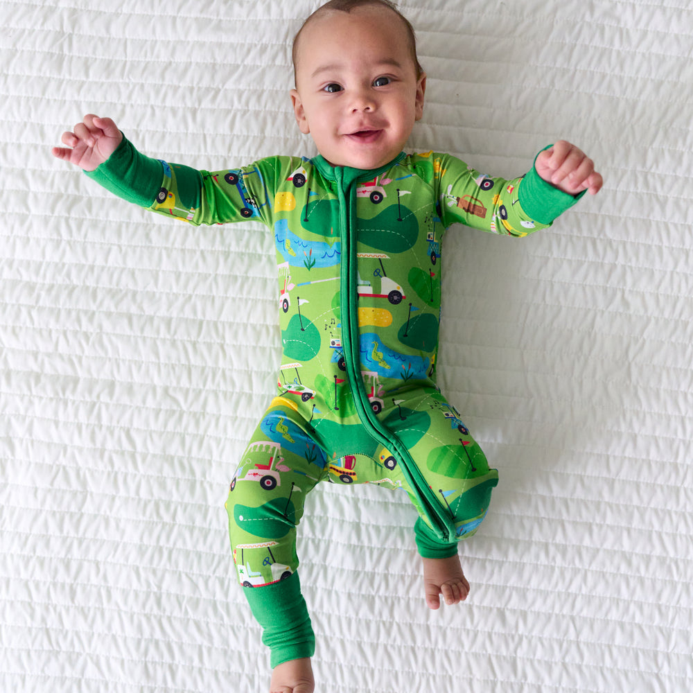 Child laying on a blanket wearing a Fairway Fun zippy