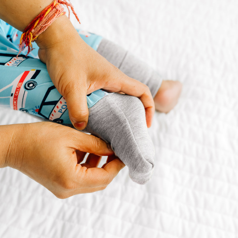 Alternate image of a child wearing a To the Rescue Zippy. Mom is demonstrating the fold over foot cuff