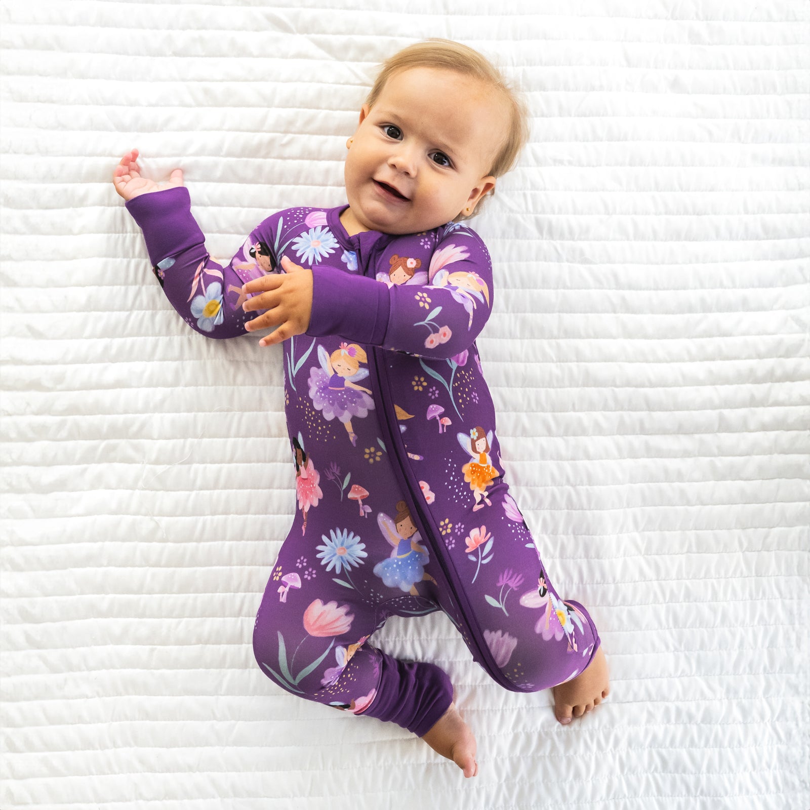 Top view image of baby laying down while wearing the Garden Fairies Zippy