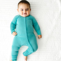 Alternate image of a child laying on a bed wearing a Glacier Turquoise zippy