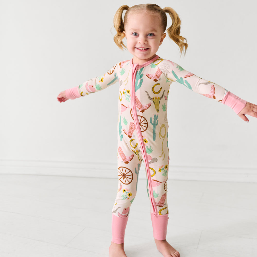 Child posing wearing a pink Ready to Rodeo zippy