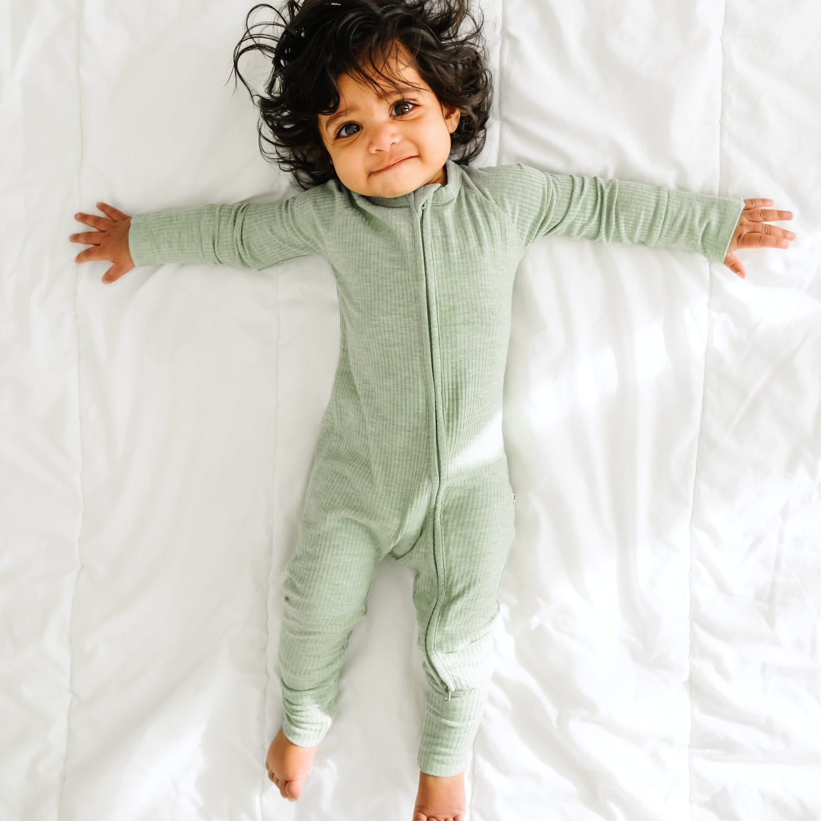 Alternate image of a child playing on a bed wearing a Heather Sage Ribbed zippy