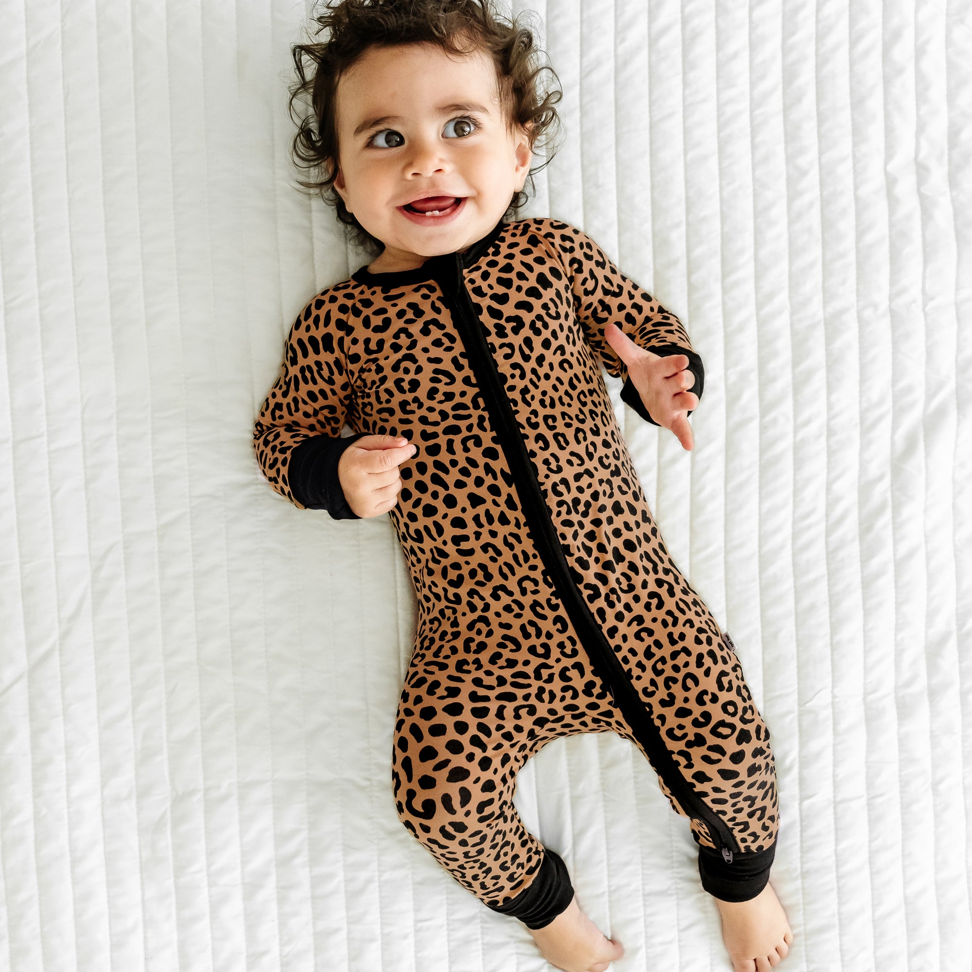 Top view image of baby laying down while wearing the Classic Leopard Zippy