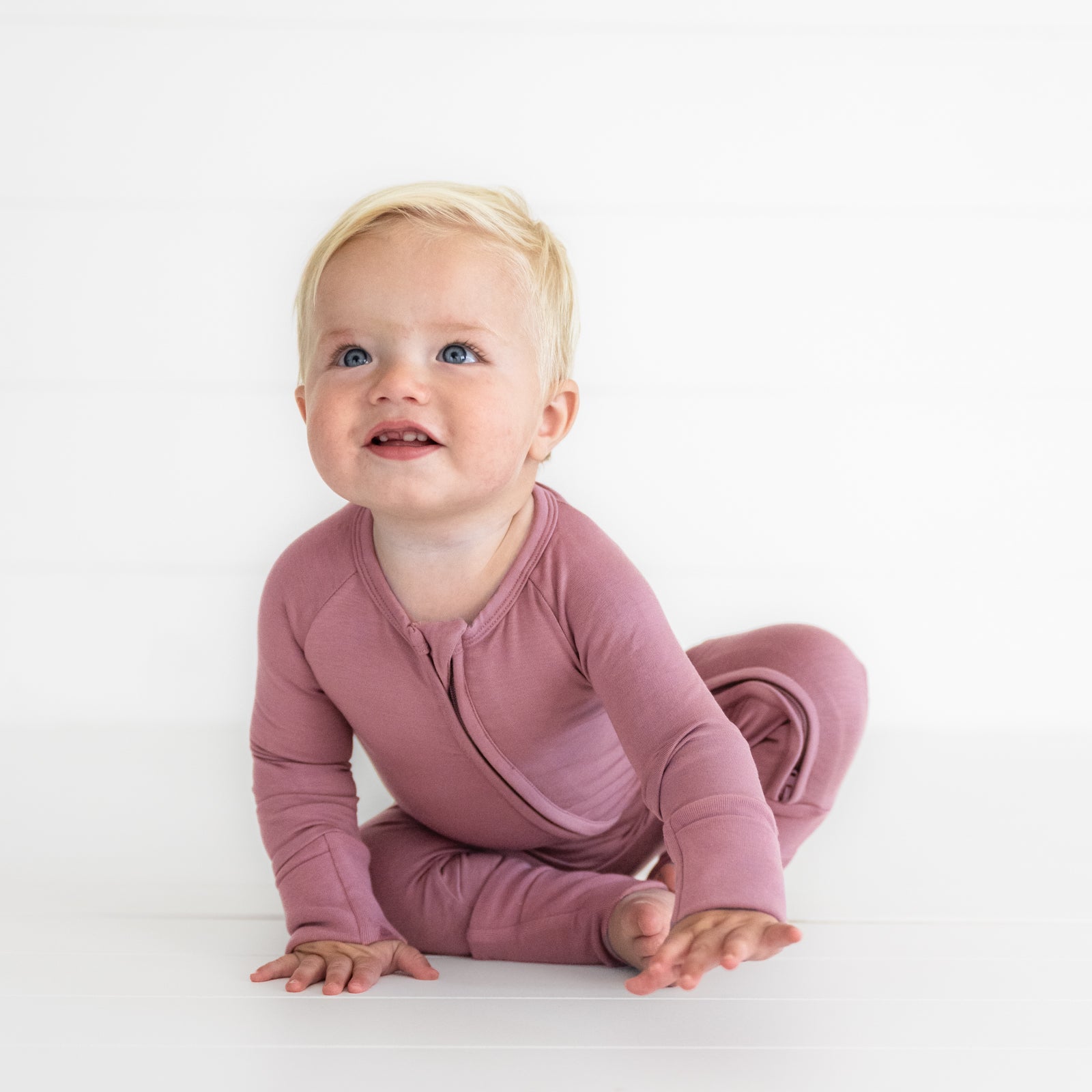 Child sitting wearing a Cozy Dusty Plum zippy
