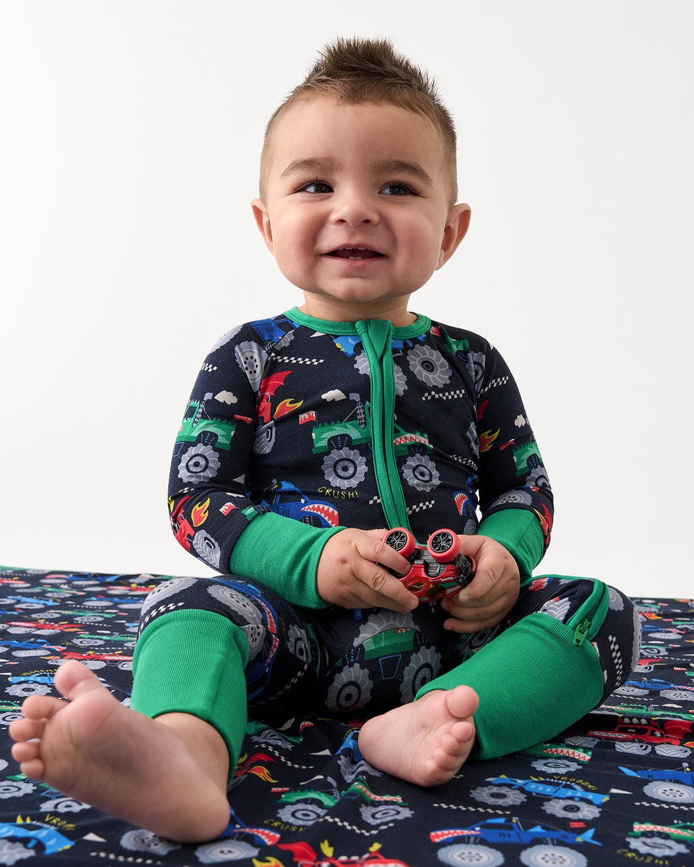 Sitting baby wearing the Monster Truck Madness Zippy