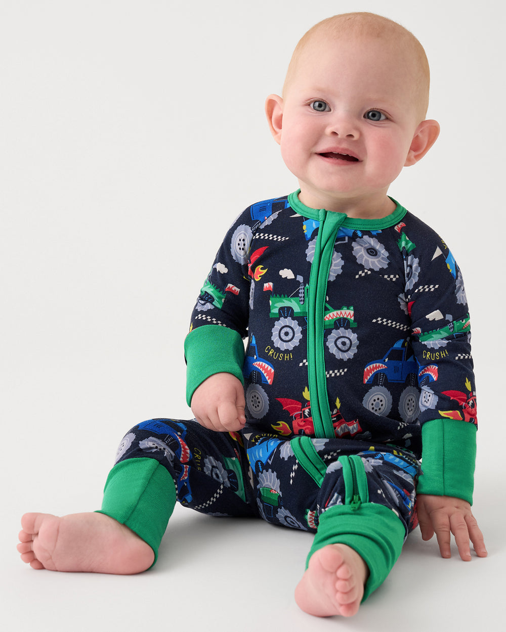 Sitting baby wearing the Monster Truck Madness Bamboo Footie