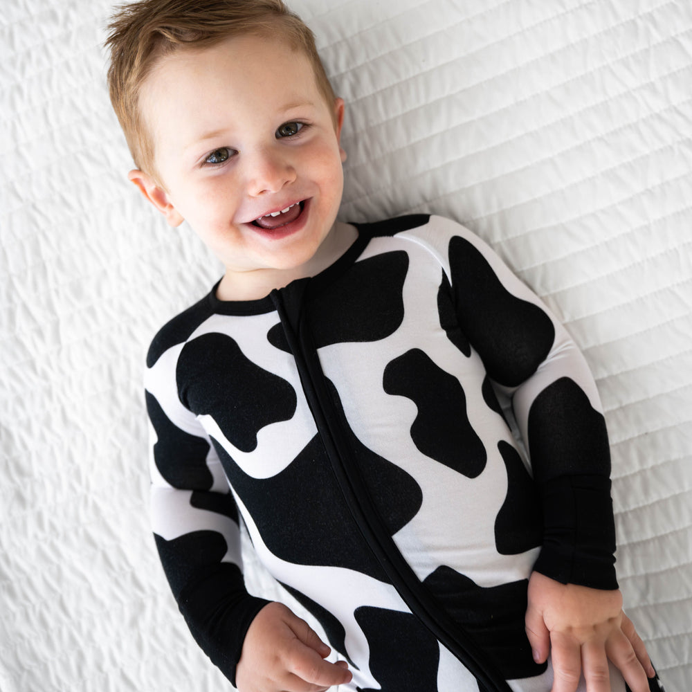 Top view image of boy laying down while wearing the Moo Crew Zippy