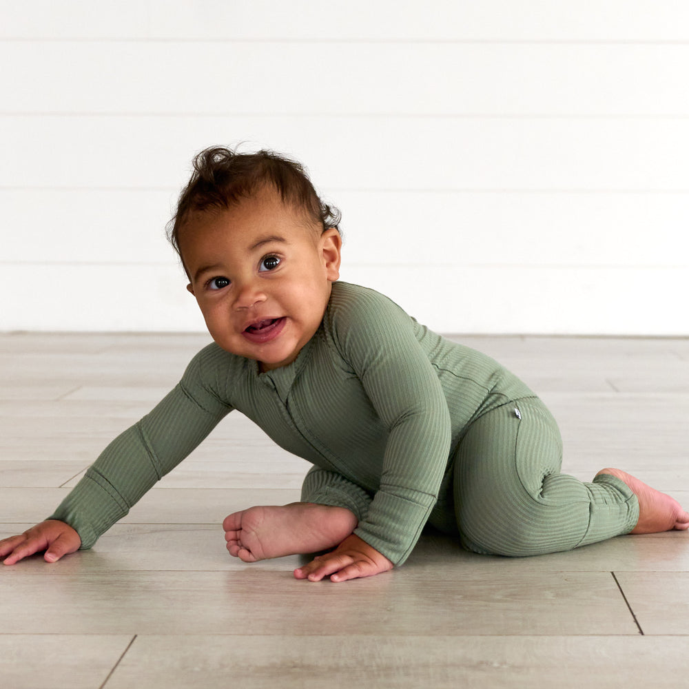 Baby crawling while wearing the Moss Ribbed Zippy