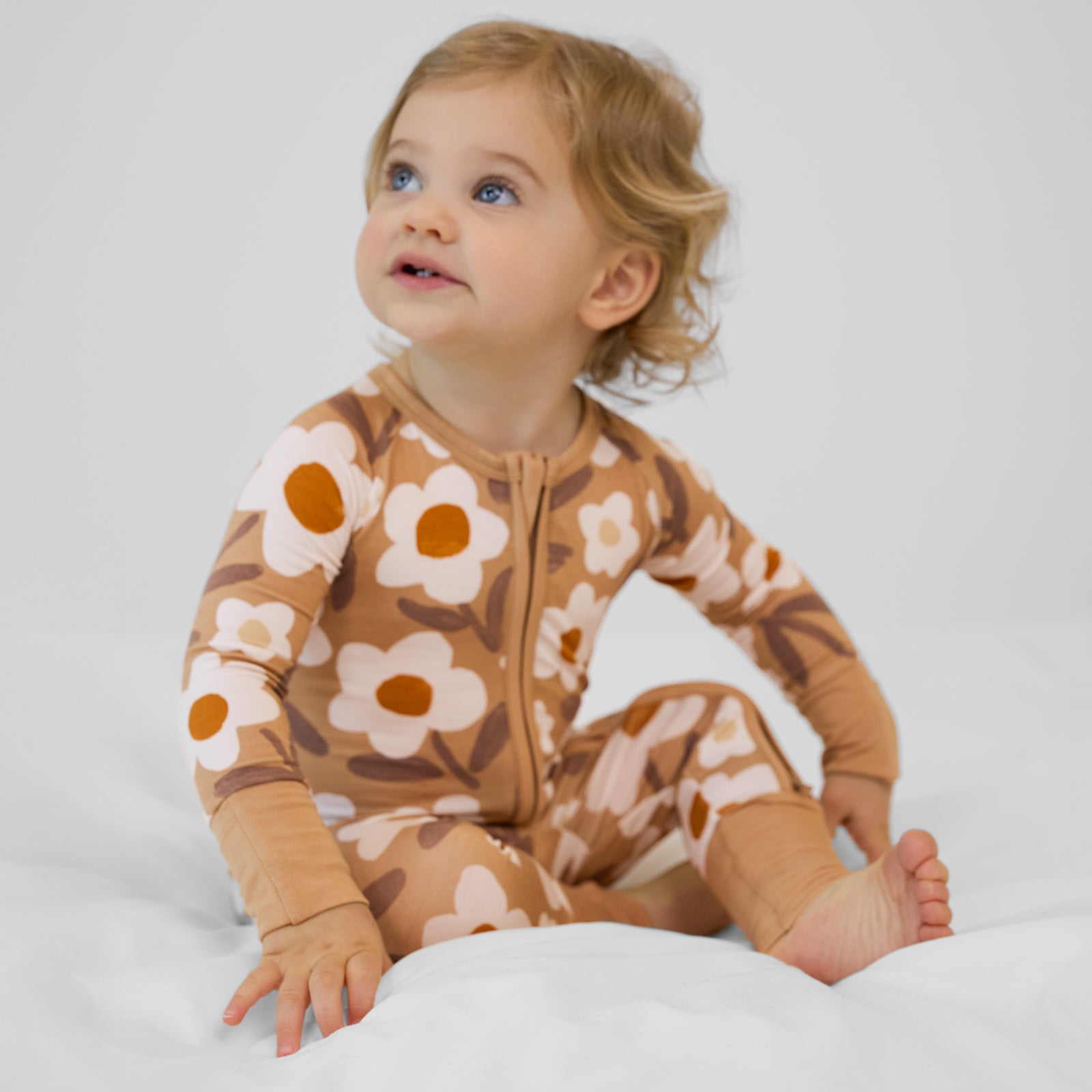 image of a child on a bed wearing a Daisy Daydream zippy