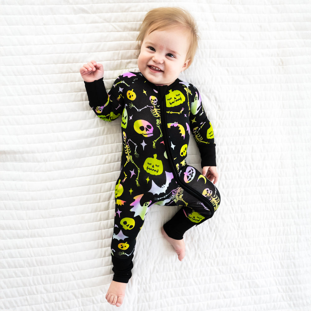 Child laying on a bed wearing a Cool Ghouls zippy