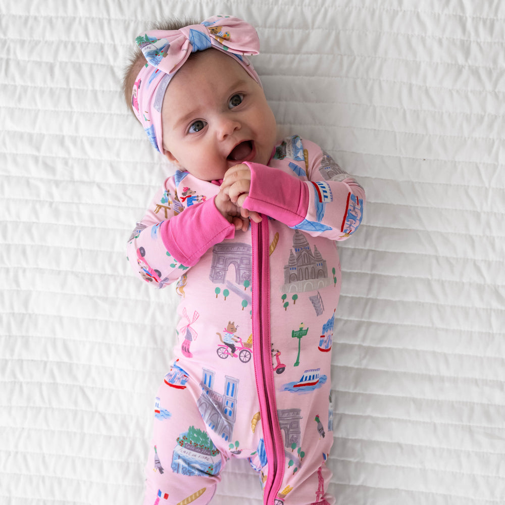 Alternative top view image of baby laying down and wearing the Pink Weekend in Paris Zippy and Luxe Bow