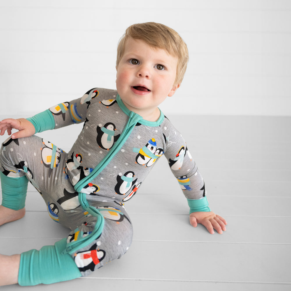 Child sitting wearing a Penguin Party zippy