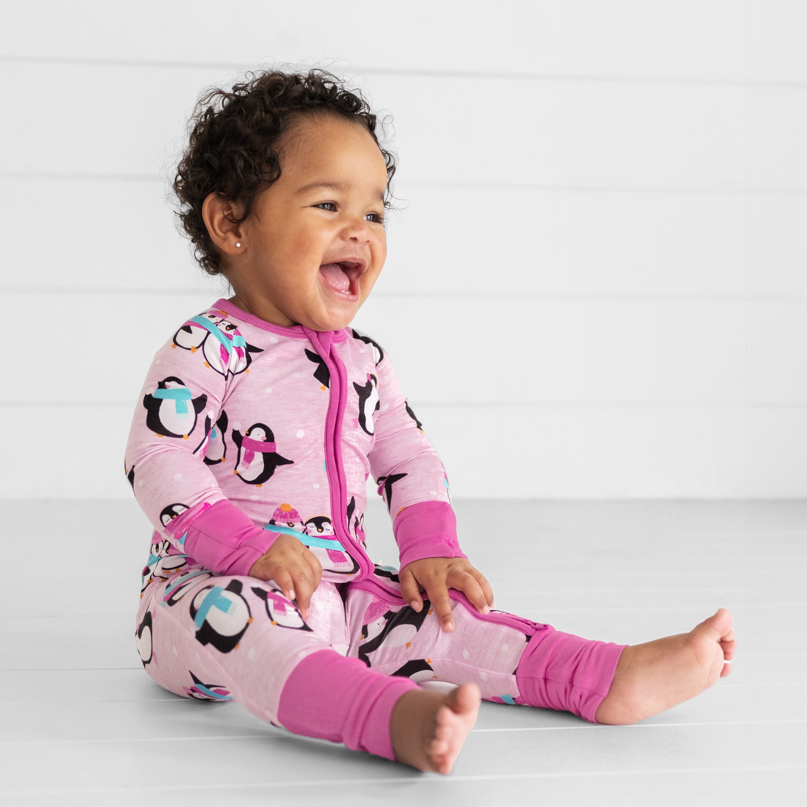 child sitting wearing a Pink Penguin Party zippy