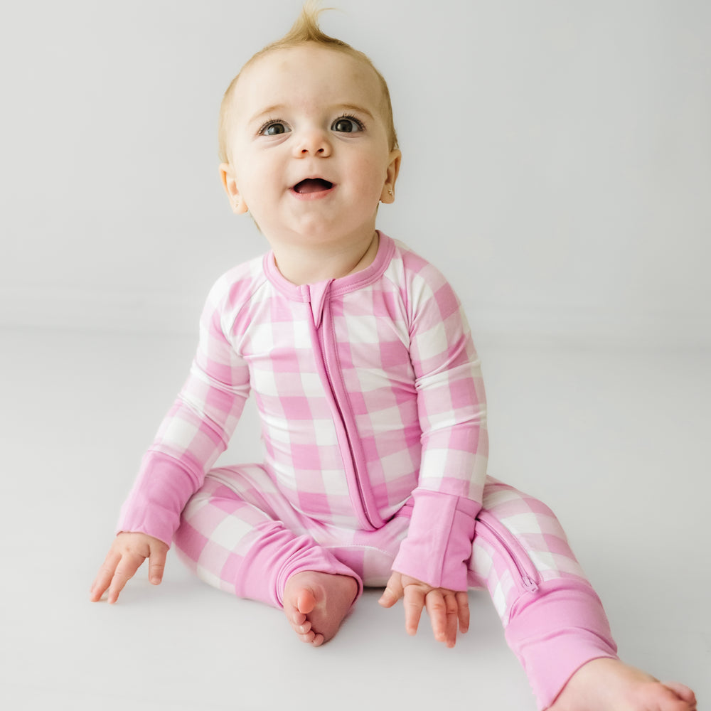 Click to see full screen - Child sitting wearing a Pink Gingham zippy