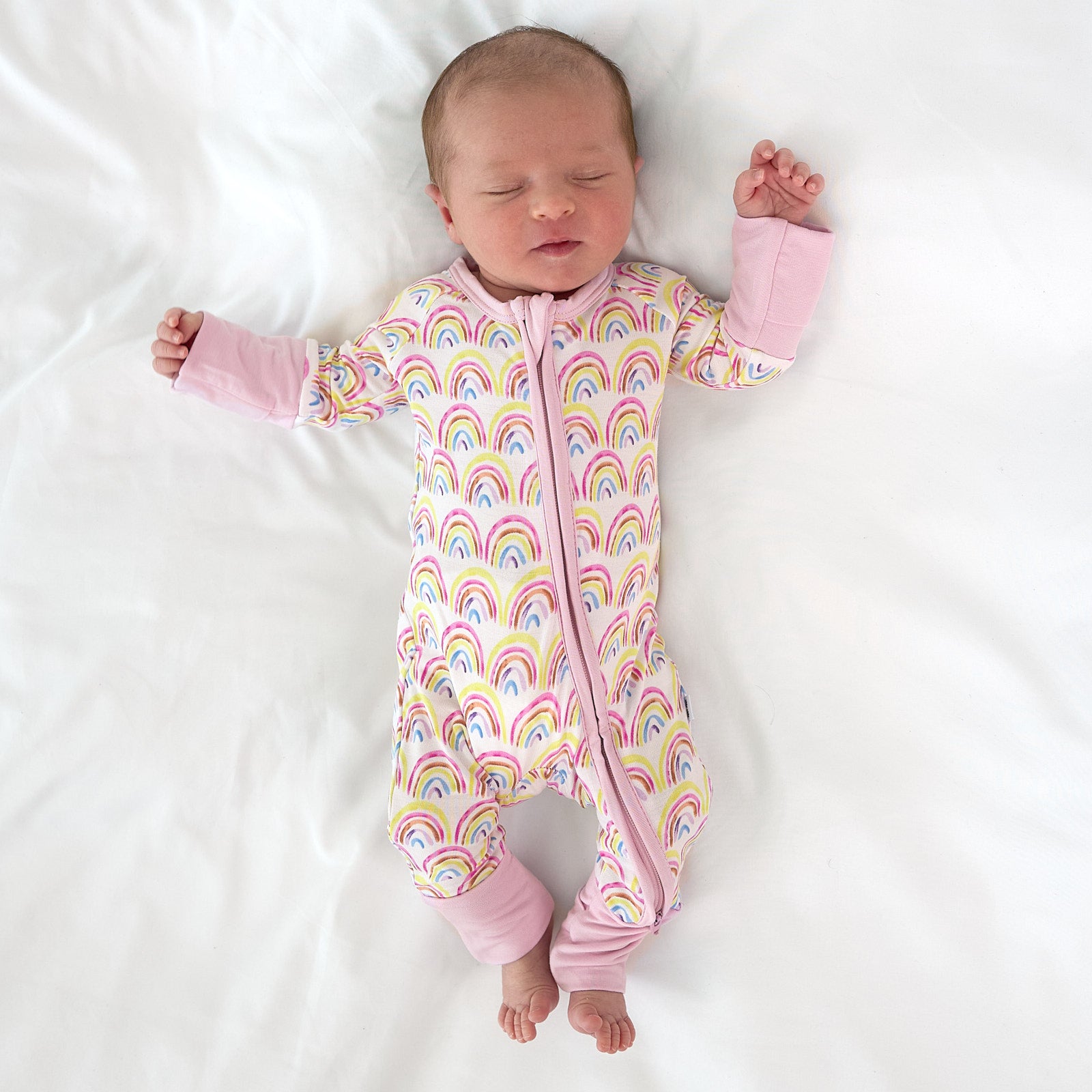 baby wearing pastel rainbows zippy sleeping