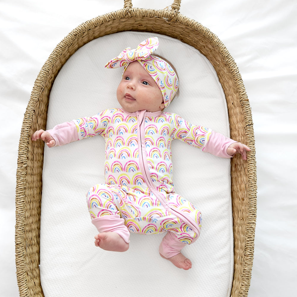 baby in basket wearing pastel rainbows zippy and luxe bow