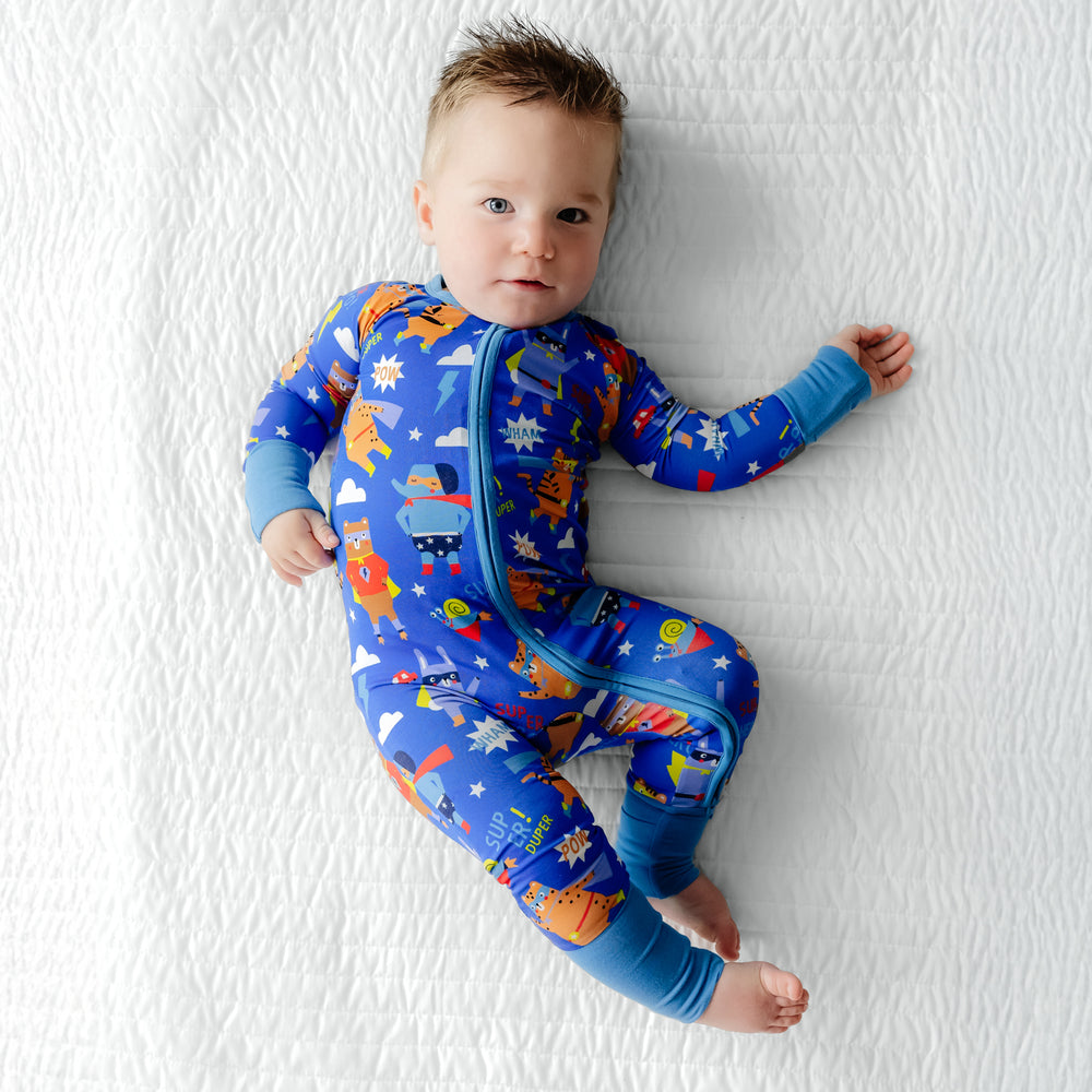 Child laying wearing the Blue Sleepy Heroes Zippy