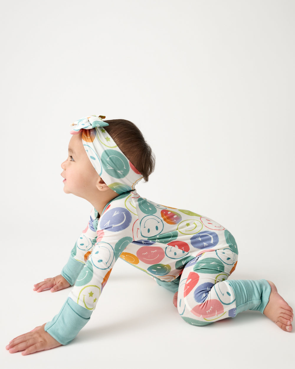 Crawling baby wearing the Positive Vibes Zippy and Luxe Bow Headband
