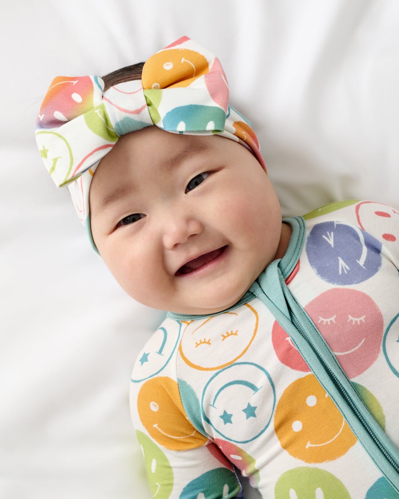 Close up of baby wearing the Positive Vibes Luxe Bow Headband and Zippy