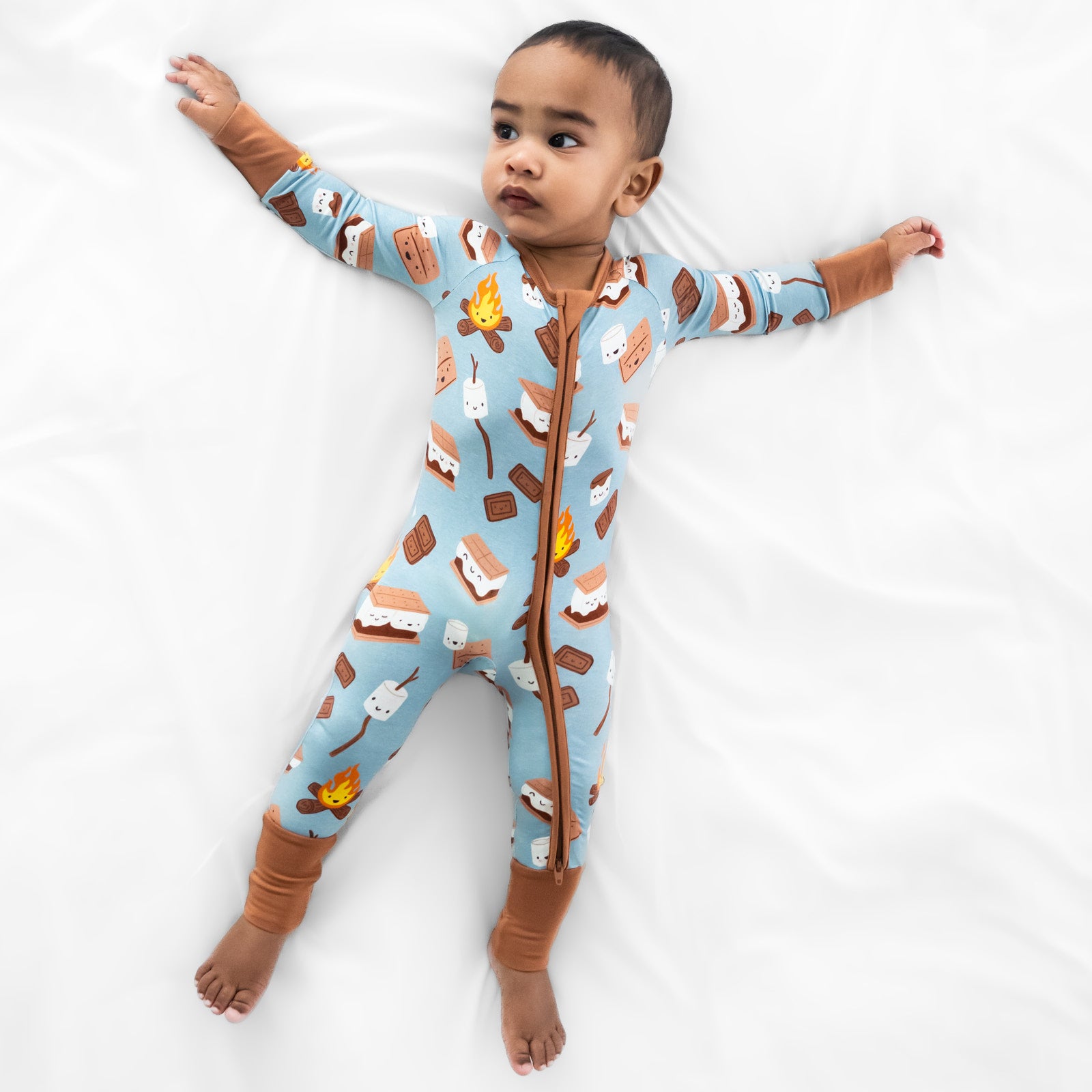 child laying on a bed wearing a S'mores Galore zippy