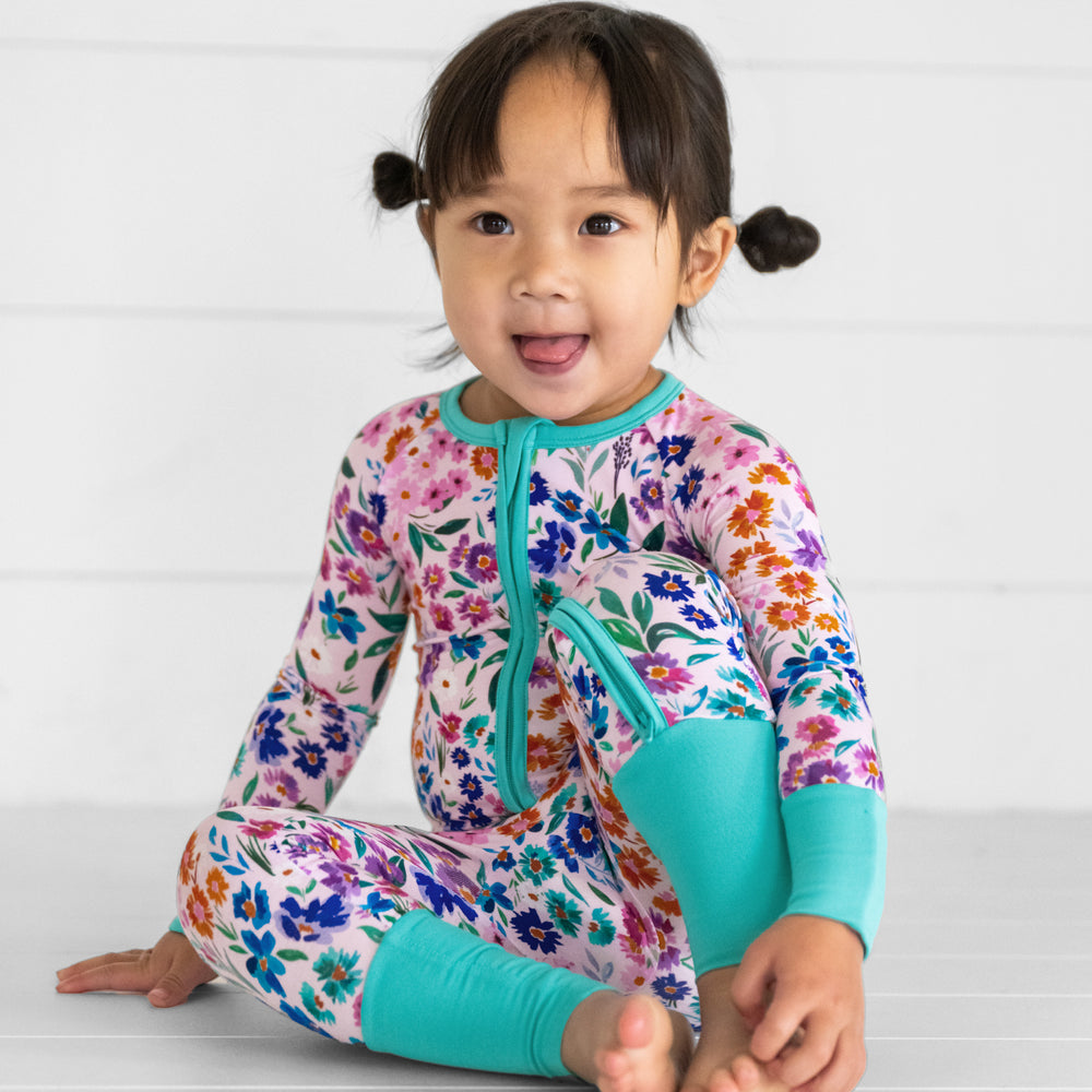 Image of a child sitting wearing a Sweet Pea Floral zippy