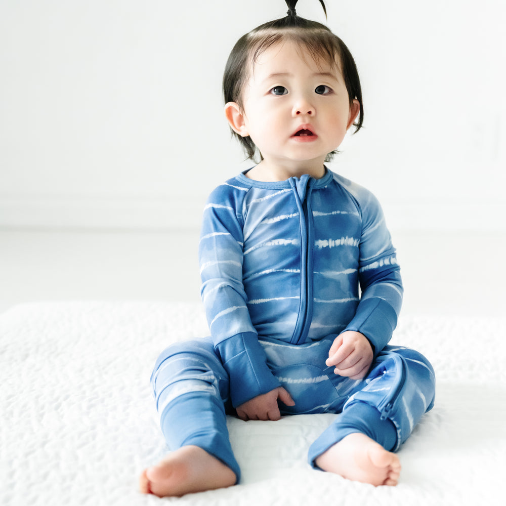 Child sitting on the ground wearing a Blue Tie Dye Dreams zippy