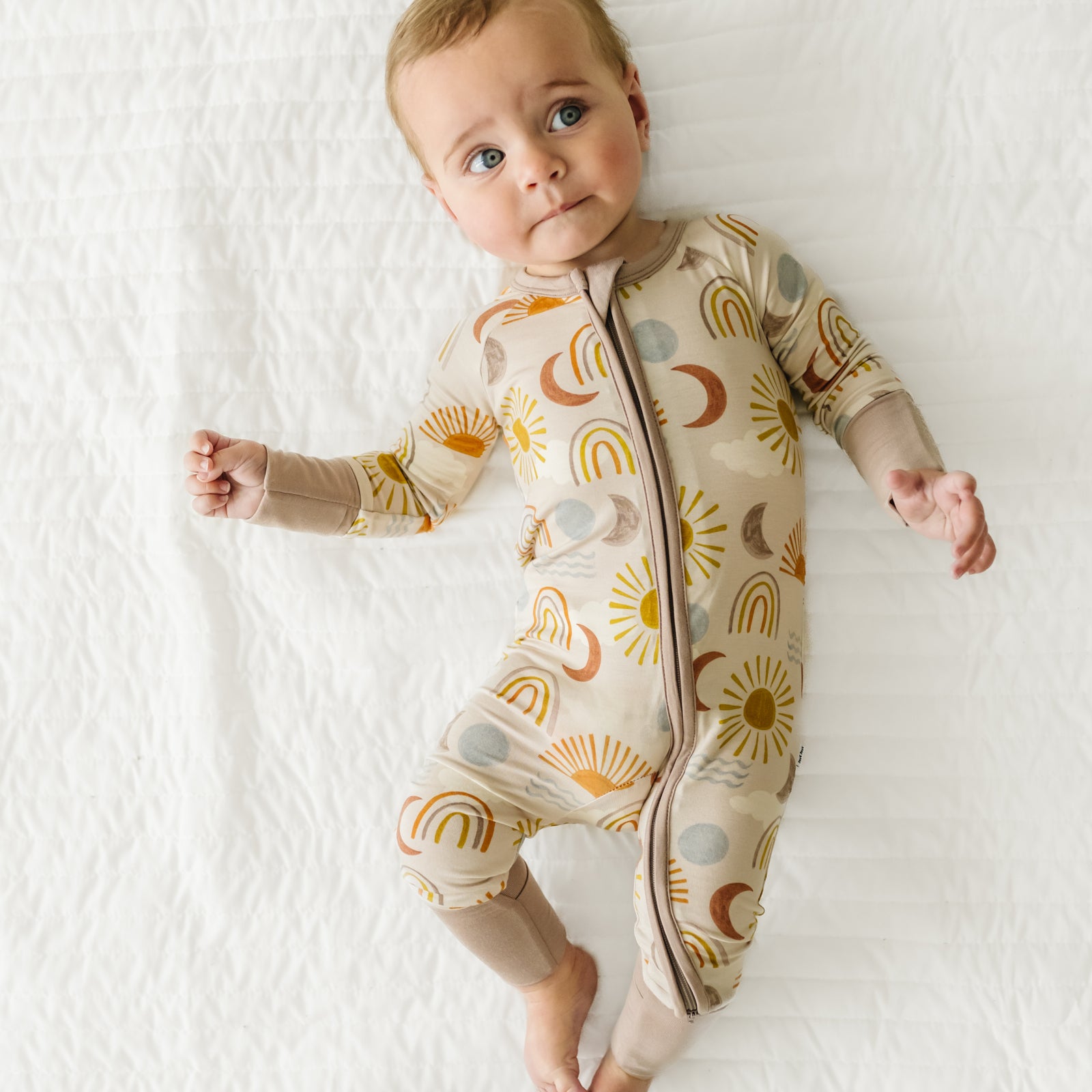 Child laying on a bed wearing a Desert Sunrise Zippy