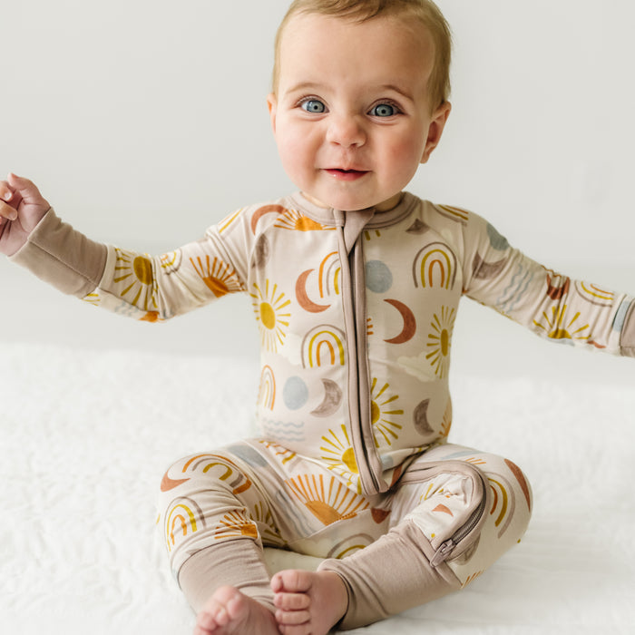 Child sitting wearing a Desert Sunrise zippy