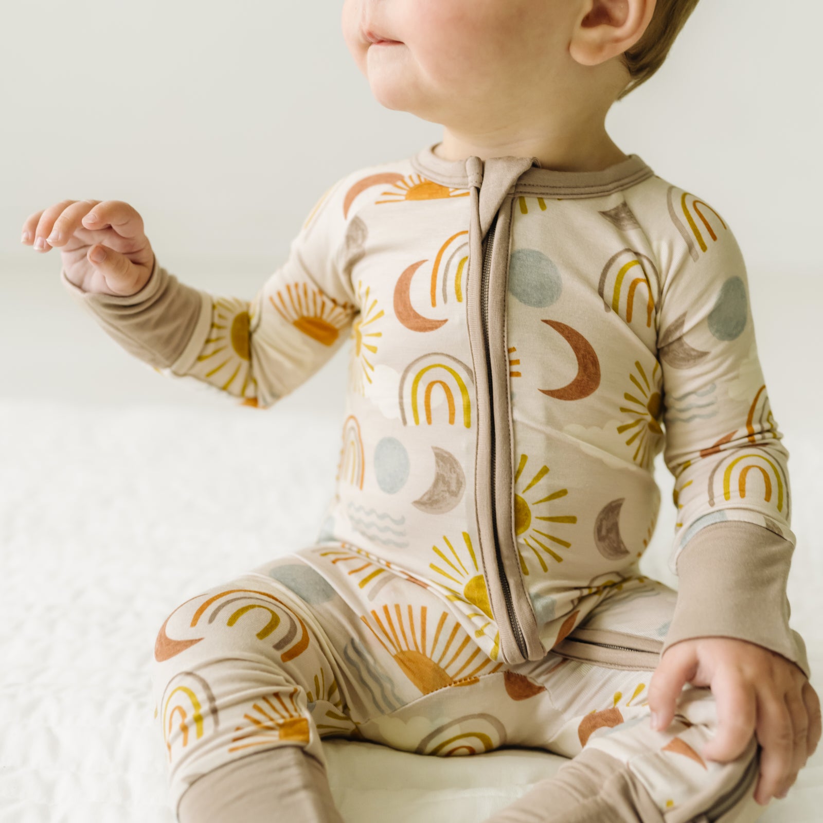 Close up image of a child sitting wearing a Desert Sunrise zippy