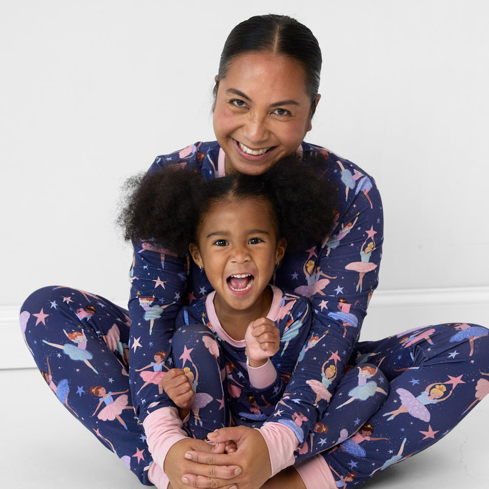 Image of a mother and daughter cuddling together wearing matching Twilight Ballet pjs in women's top and bottom and children's two piece sets