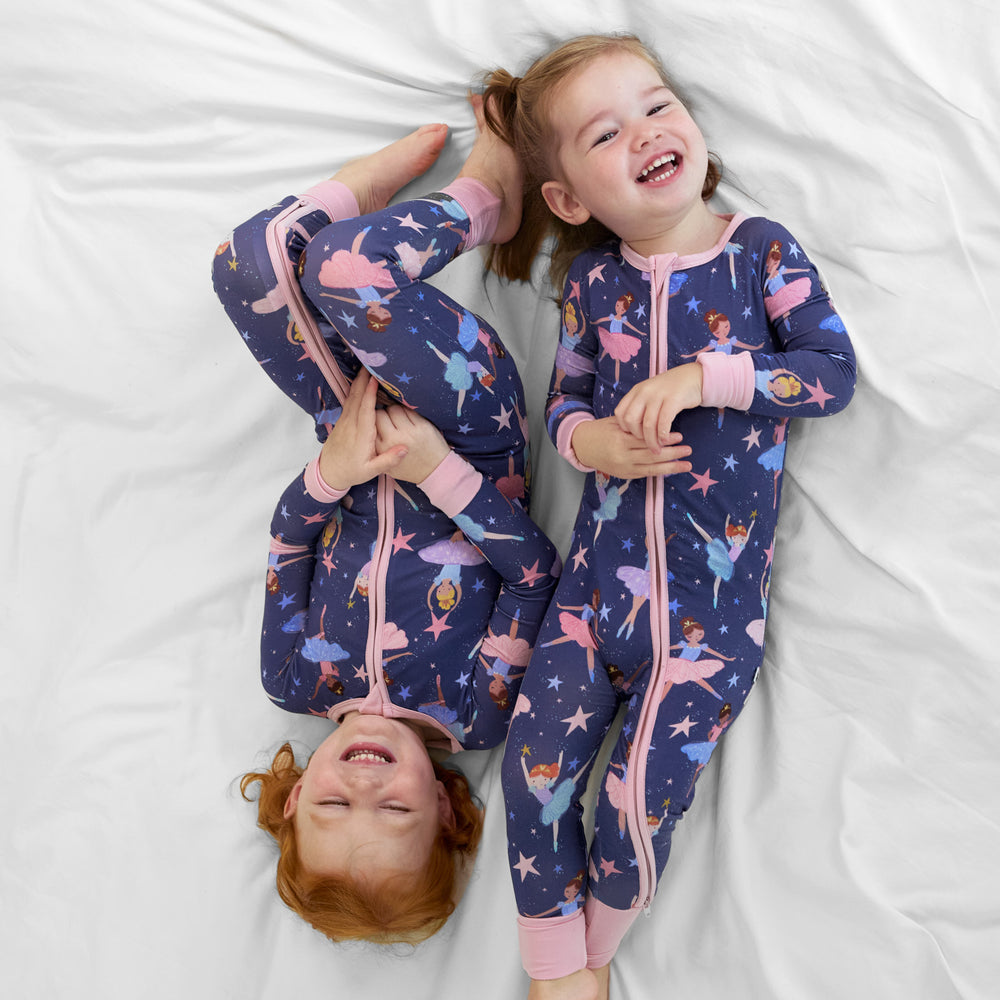 two children laying on a bed together wearing matching Twilight Ballet printed zippies