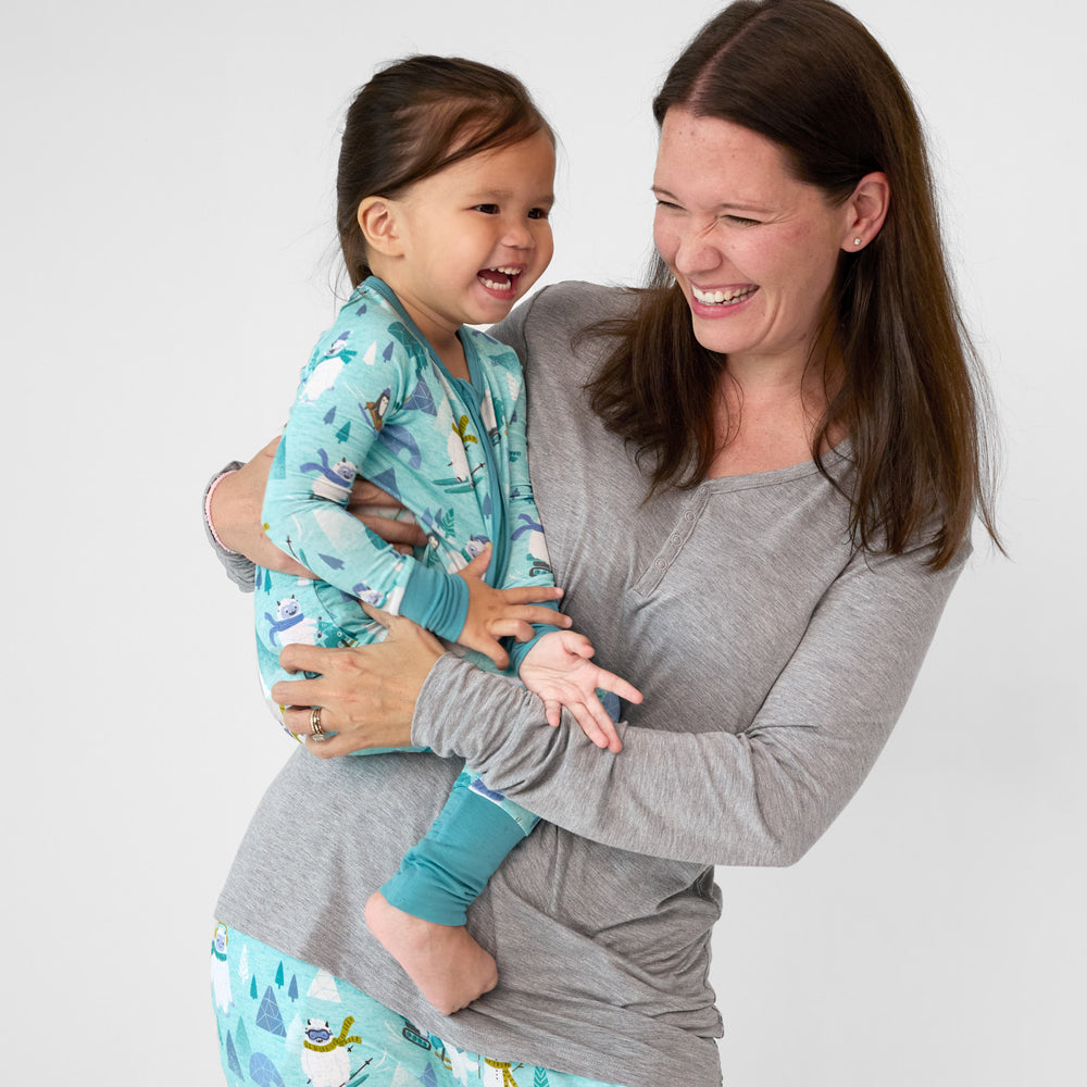 Mom holding a Yeti Snow Day zippy. Mom is wearing a women's HEather Gray pj top