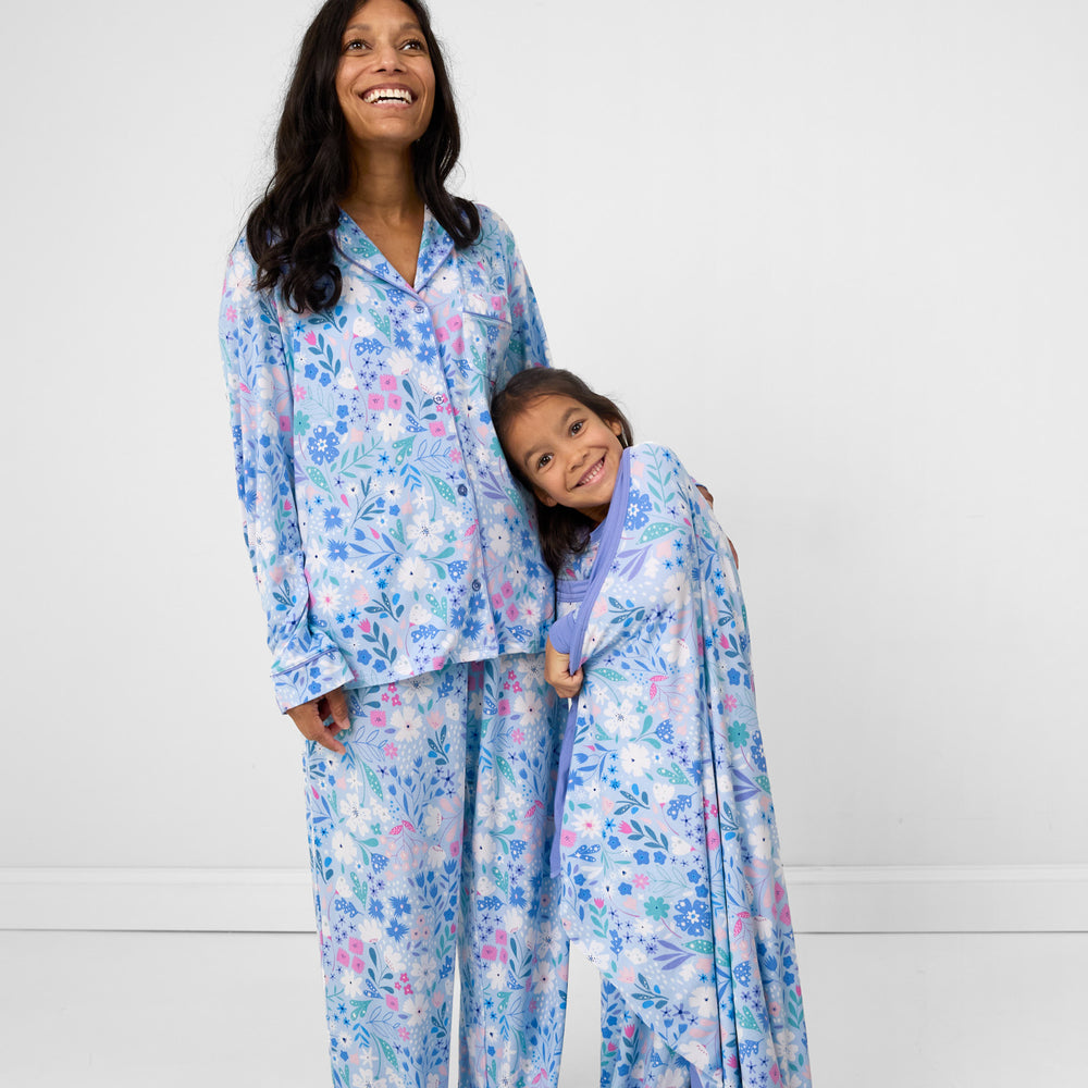 Image of a woman wearing a women's Magical Meadow two peice pj set, hugging her daughter wearing a matching Magical Meadow cloud blanket