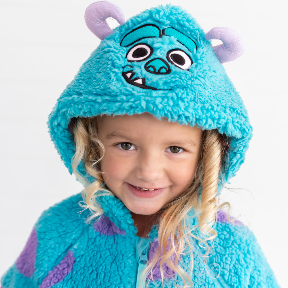 Close up image of smiling girl showing the hood detail on the Disney Monsters, Inc. Sulley Sherpa Zip Hoodie