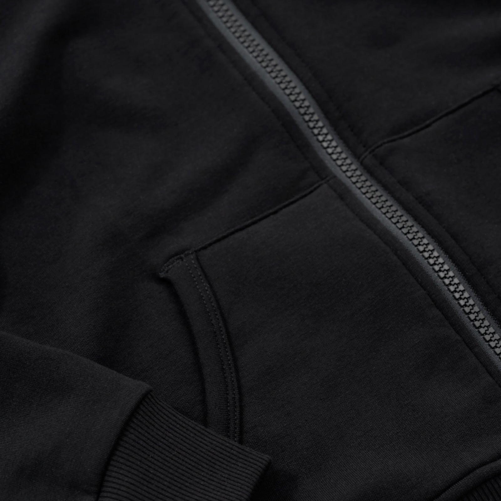 Close up detail on the pocket detail on the Black Zip Hoodie