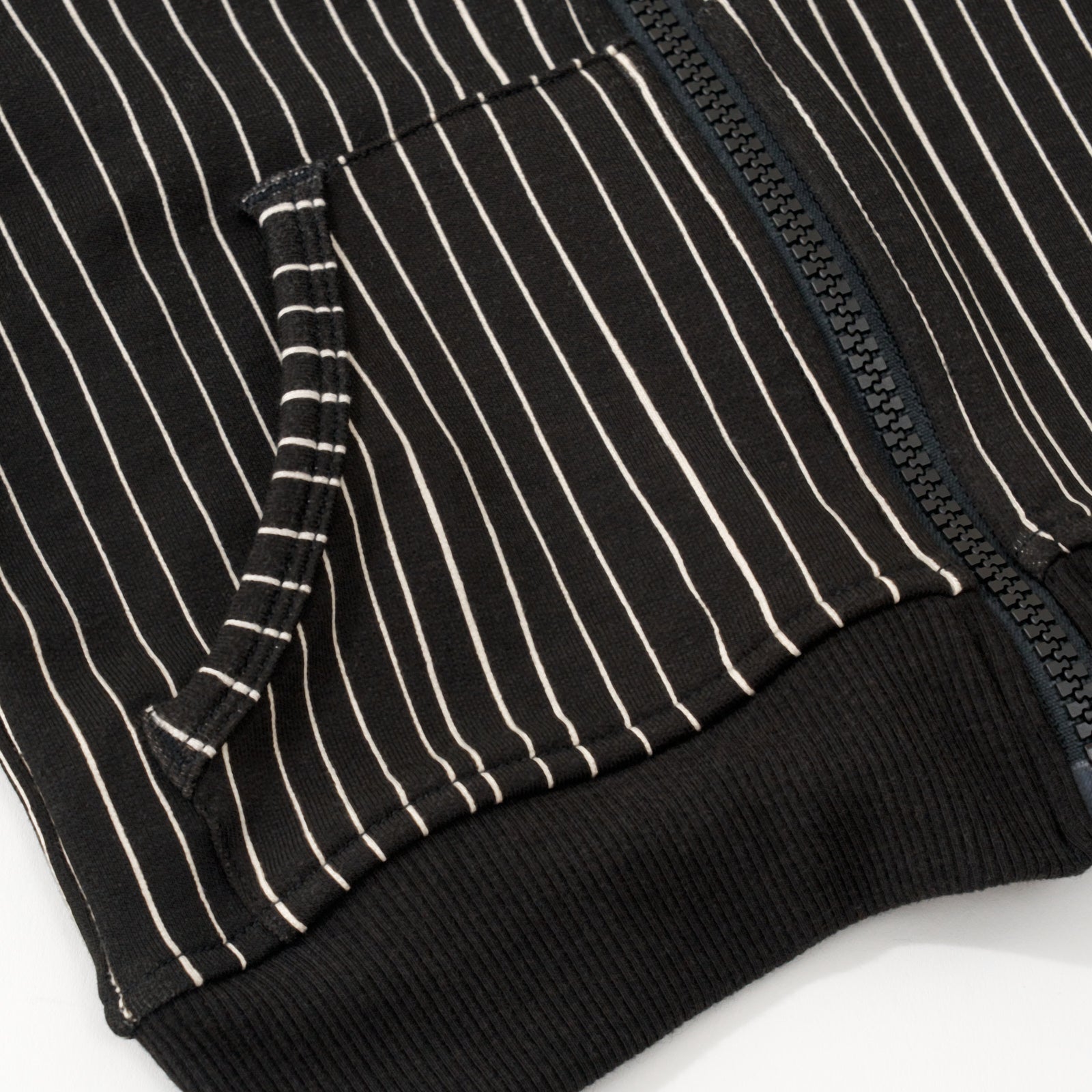 Close up flat lay image of the pocket and lower zipper details on the Disney Jack Skellington Zip Hoodie