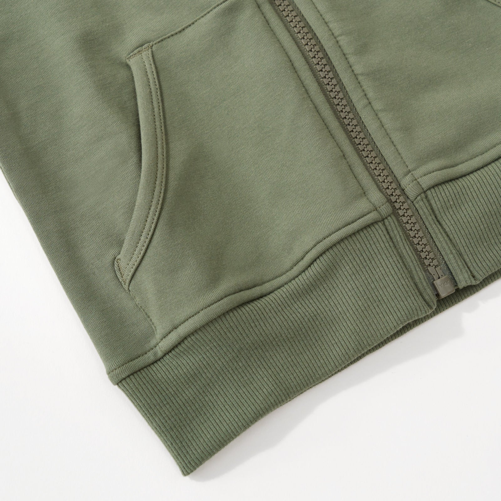 Close up image of the zipper detail for the Moss Zip Hoodie