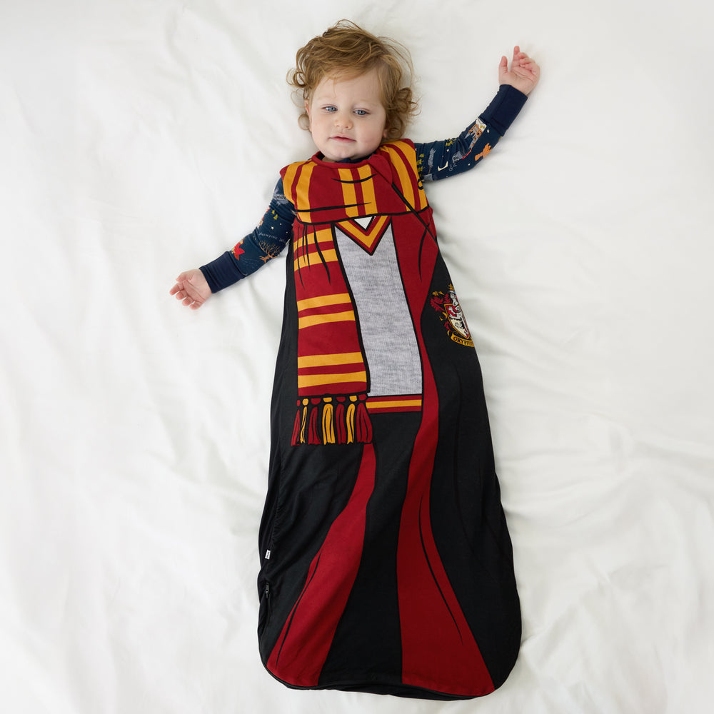 Child laying on a bed wearing a Harry Potter™ Gryffindor™ Robe Costume Sleepy Bag