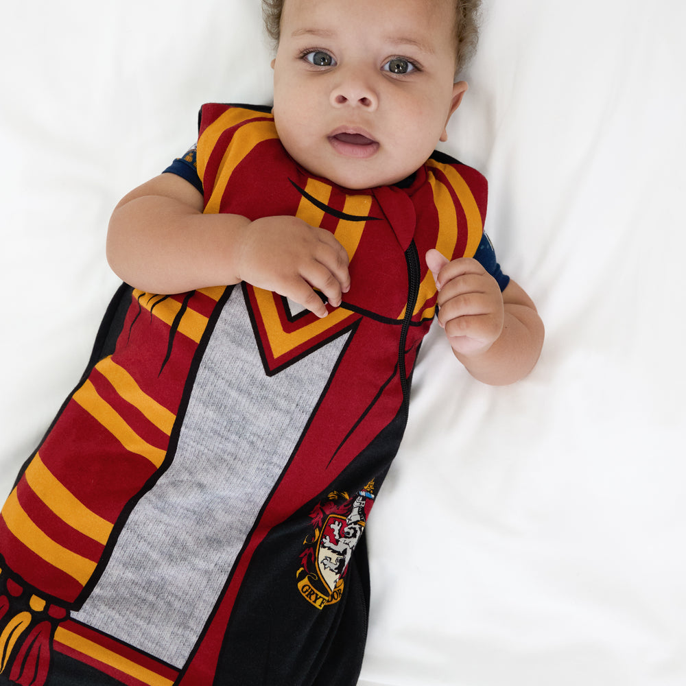 Alternate close up image of a child laying on a bed wearing a Harry Potter™ Gryffindor™ Robe Costume Sleepy Bag