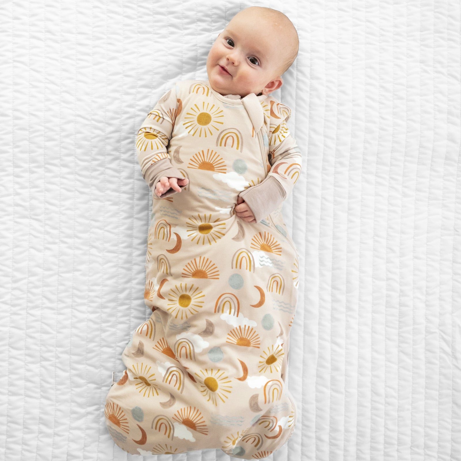 Child laying on a bed in a Desert Sunrise printed sleepy bag