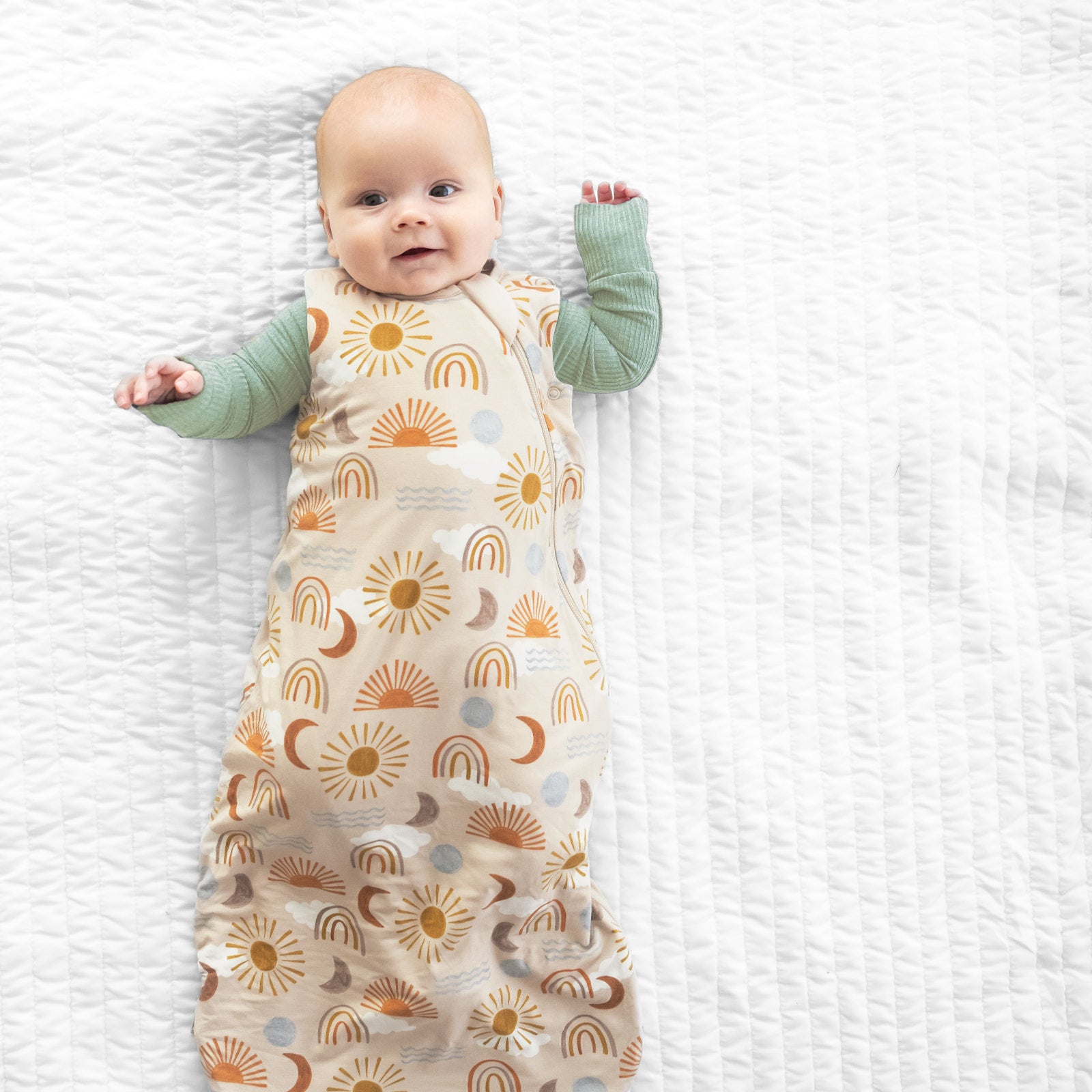 Alternate image of a child laying on a bed in a Desert Sunrise printed sleepy bag