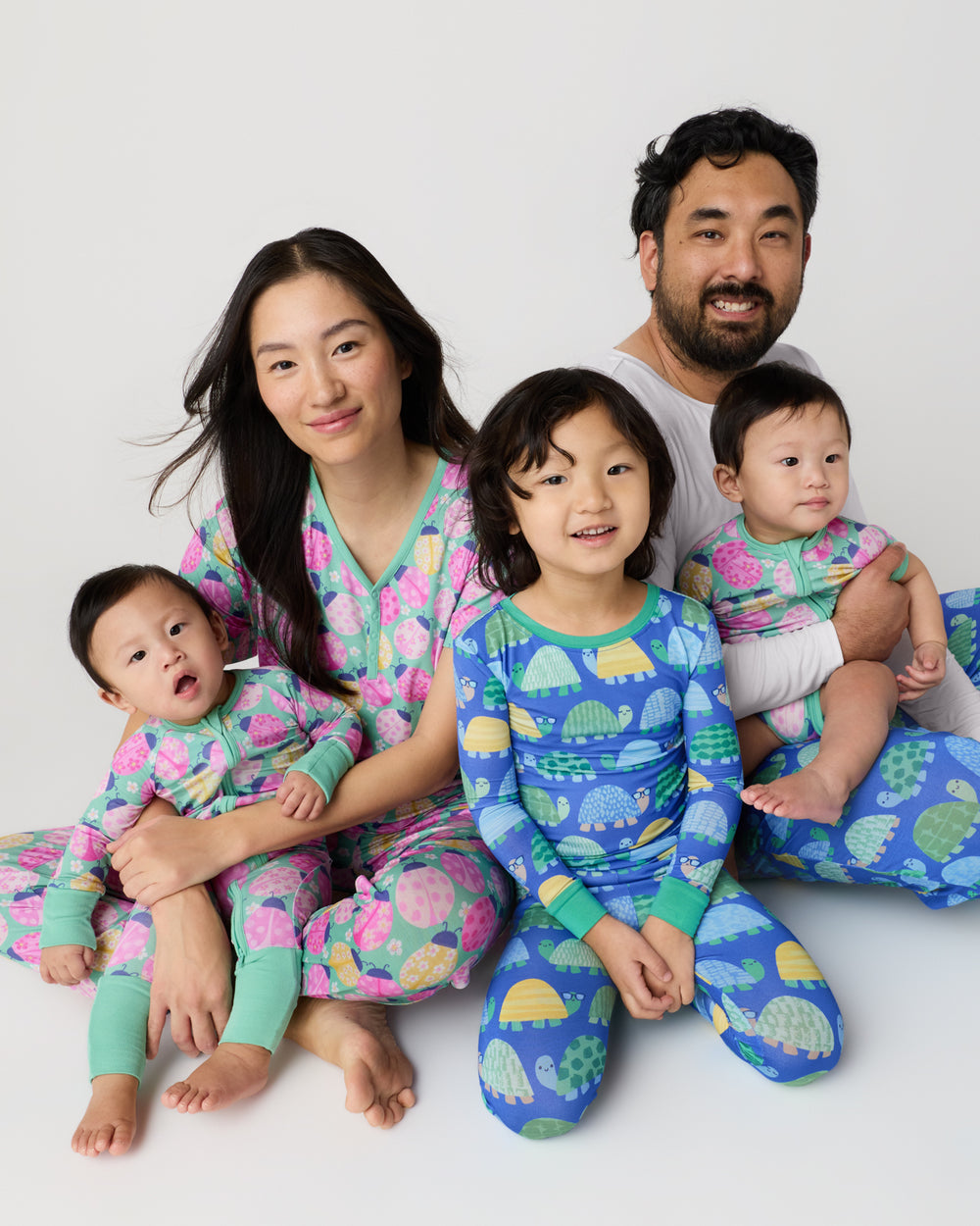 Family of five wearing ladybug and turtle print pajamas